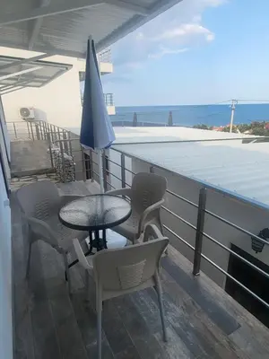 a patio with a table and chairs and an umbrella at Bungalovi Arabela in Utjeha