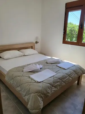 a bedroom with a large bed with pillows and a window at Bungalovi Arabela in Utjeha