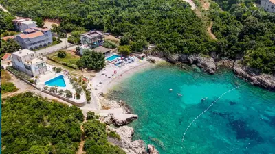 an aerial view of a beach with people in the water at Bungalovi Arabela in Utjeha