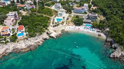 an aerial view of a beach with people in the water at Bungalovi Arabela in Utjeha
