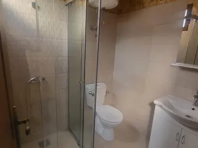 a bathroom with a shower and a toilet and a sink at Bungalovi Arabela in Utjeha