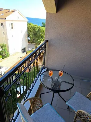 a balcony with a table and chairs and the ocean at Petrovac Studio Apartment Ana in Petrovac na Moru