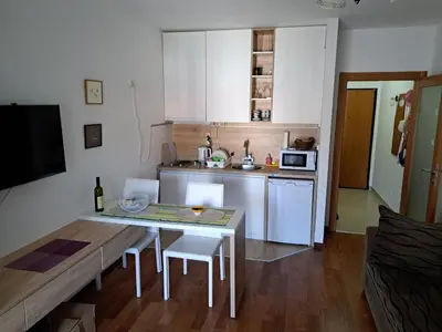 a small kitchen with a table and a dining room at Petrovac Studio Apartment Ana in Petrovac na Moru