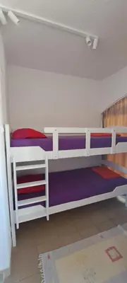 two bunk beds in a room with purple sheets at Petrovac Studio Apartment Ana in Petrovac na Moru