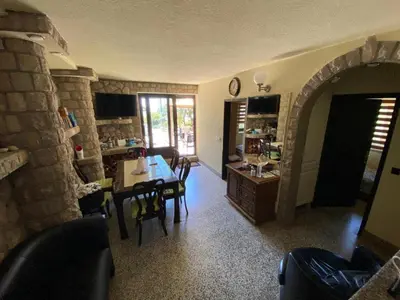 a kitchen and dining room with a table and chairs at Семейный комплекс для отдыха in Pečurice