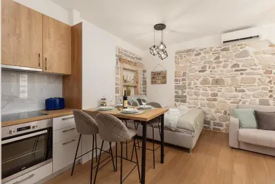 a kitchen with a table and chairs in a room at Apartman Maestral in Kotor