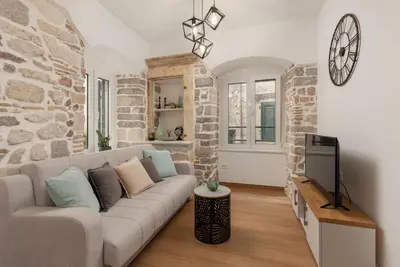 a living room with a couch and a tv at Apartman Maestral in Kotor