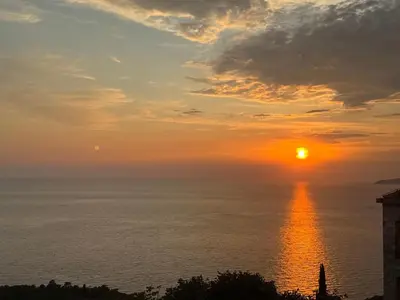 a sunset over the ocean with the sun at Castello degli Aranci Eco Resort in Petrovac na Moru