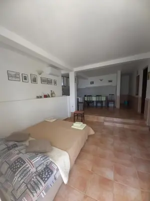 a bedroom with a bed and a living room at Apartments & Rooms Villa Anastasija in Ulcinj
