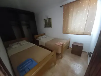 a small room with two beds and a window at Apartments & Rooms Villa Anastasija in Ulcinj
