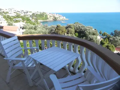 a table and chairs on a balcony with the ocean at Apartments & Rooms Villa Anastasija in Ulcinj