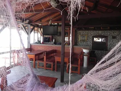 a restaurant with a table and chairs and a tv at Apartments & Rooms Villa Anastasija in Ulcinj