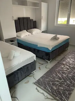 two twin beds in a room with a rug at Villa Draga in Ulcinj