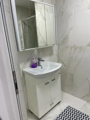 a white bathroom with a sink and a mirror at Villa Draga in Ulcinj
