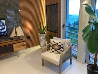 a living room with a chair and a television at The View apartment 2 in Petrovac na Moru