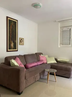 a living room with a brown couch with colorful pillows at Stan Budva - Potkosljun in Budva