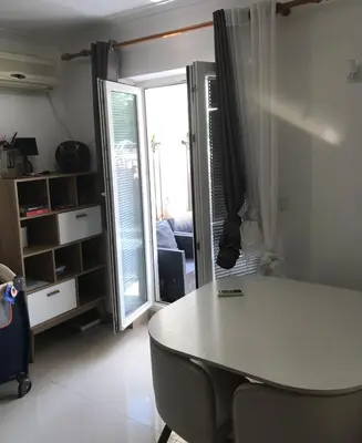 a room with a table and a couch and a window at Stan Budva - Potkosljun in Budva