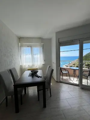 a dining room with a table and a view of the ocean at Apartments BABKO in Bar