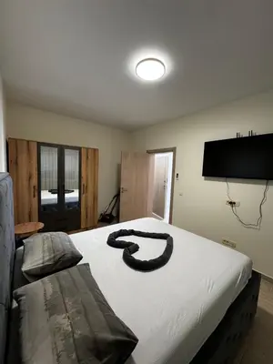 a snake laying on a bed in a bedroom at Apartments BABKO in Bar
