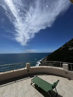 a table and a chair on a balcony overlooking the ocean at Apartments BABKO in Bar
