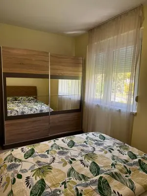a bedroom with a bed with a large wooden headboard at Apartments BABKO in Bar