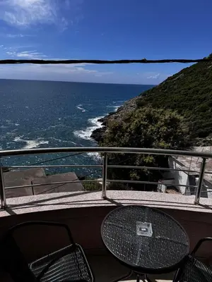 a table and chairs on a balcony overlooking the ocean at Apartments BABKO in Bar