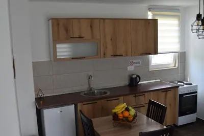 a kitchen with a table with a bowl of fruit on it at KenDar Family Apartments in Ulcinj