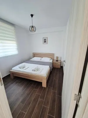 a bedroom with a bed and a wooden floor at KenDar Family Apartments in Ulcinj
