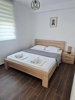 a bedroom with a bed with two slippers on it at KenDar Family Apartments in Ulcinj
