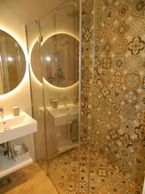 a bathroom with a shower with a sink and a mirror at ROSE Downtown in Podgorica