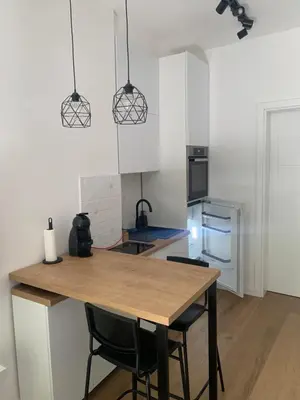 a kitchen with a wooden table and two chairs at ROSE Downtown in Podgorica
