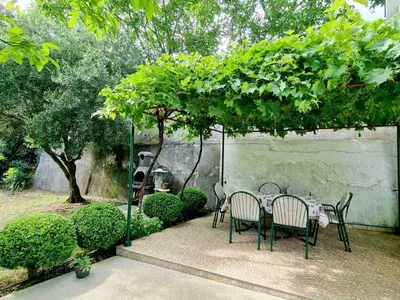 a table and chairs under a canopy in a garden at Cozy House Haj Nehaj in Sutomore