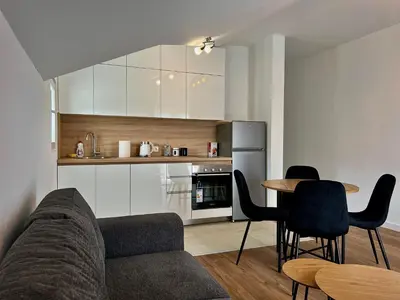 a living room with a couch and a table and a kitchen at Villa Bubanja with shared pool in Kotor