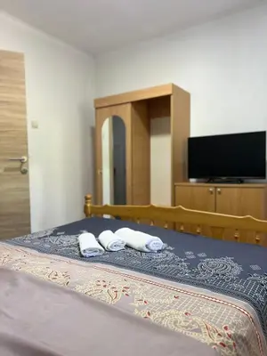 a bedroom with a bed with two towels and a tv at Villa Bubanja with shared pool in Kotor