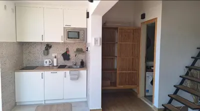 a kitchen with white cabinets and a microwave at Aloft Apartment in Budva