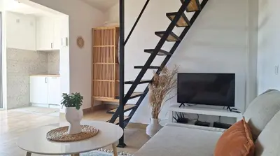 a living room with a staircase and a tv at Aloft Apartment in Budva