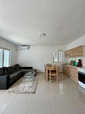 a living room with a black couch and a table at Hida Ile apartments in Ulcinj