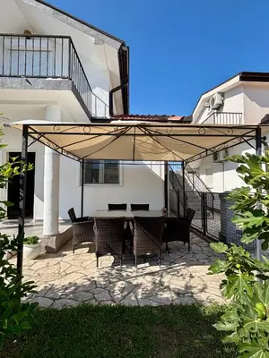 a patio with a table and chairs under an umbrella at Hida Ile apartments in Ulcinj
