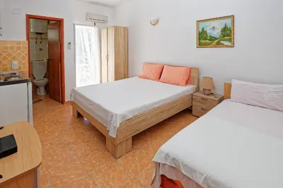 a bedroom with two beds and a bathroom with a toilet at Apartments Ajla in Utjeha