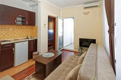 a living room with a couch and a kitchen at Apartments Ajla in Utjeha