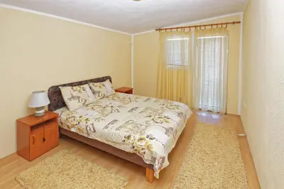 a bedroom with a bed and a window and a rug at Apartments Ajla in Utjeha