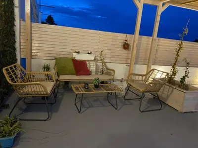 a patio with two chairs and a couch and two tables at Apartments Casa Pineta in Ulcinj