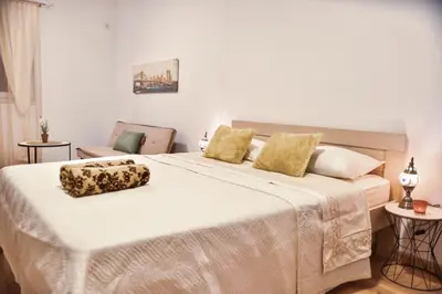 a bedroom with a large white bed with yellow pillows at Apartments Casa Pineta in Ulcinj