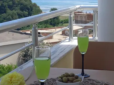 a table with two glasses of wine on a balcony at Apartments Verona in Ulcinj