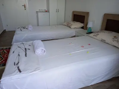 two beds with white sheets and towels on them at Apartments Verona in Ulcinj