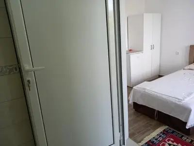 a small room with a bed and a sliding glass door at Apartments Verona in Ulcinj