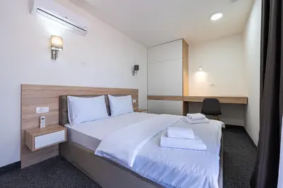 a bedroom with a large bed with two towels on it at Rooftop Apartments & Rooms in Budva