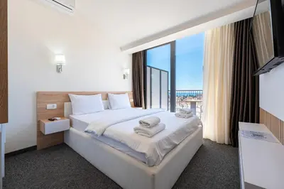 a hotel room with a bed and a large window at Rooftop Apartments & Rooms in Budva
