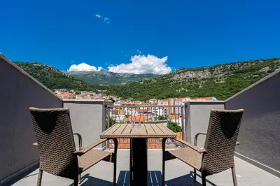 a table and chairs on a balcony with a view at Rooftop Apartments & Rooms in Budva