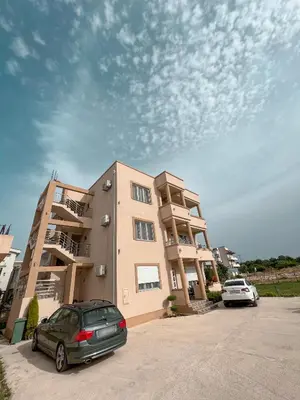 a car parked in a parking lot next to a building at Dragaj Apartments in Ulcinj